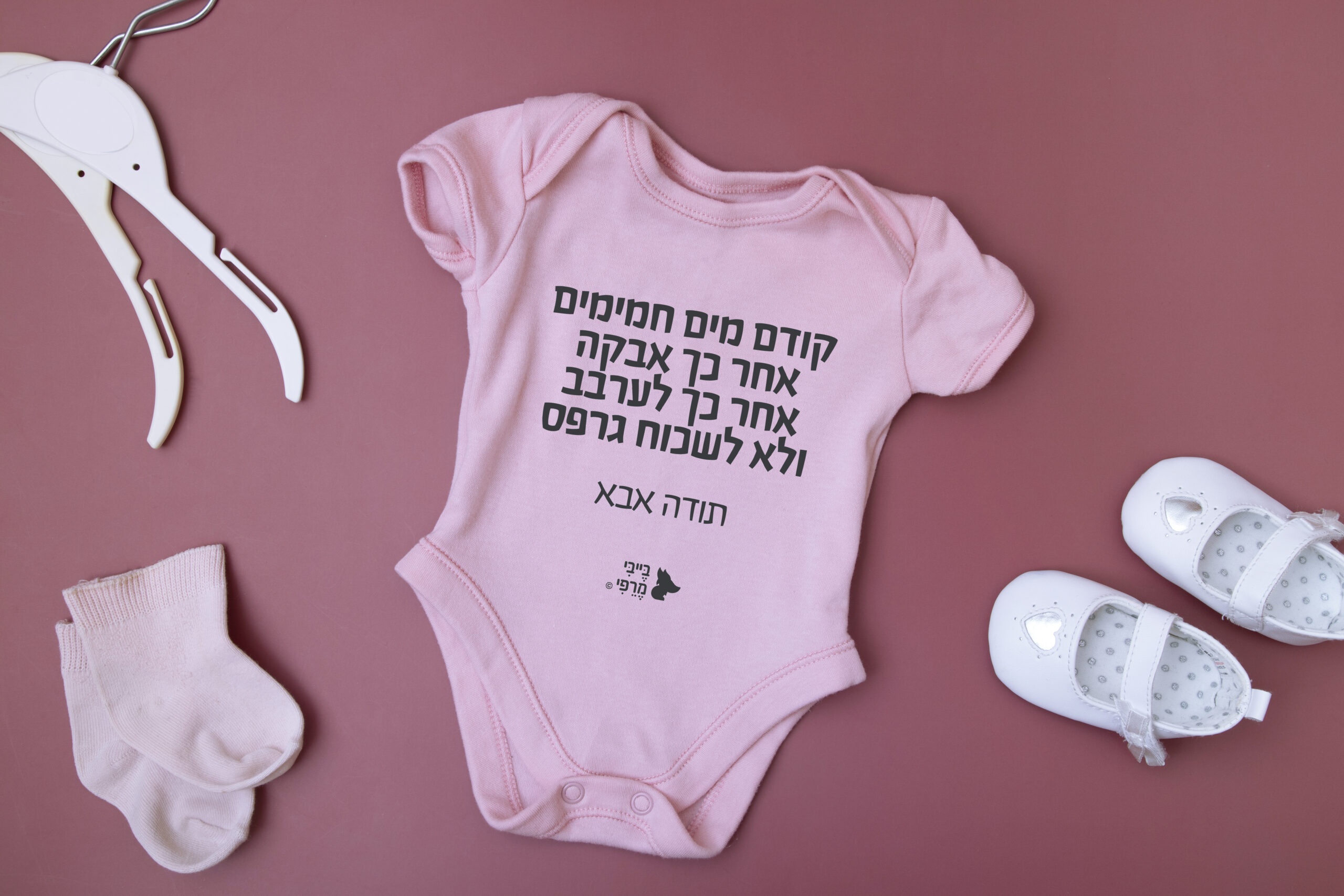 Baby clothes mock up for your text on a pink background with accessories